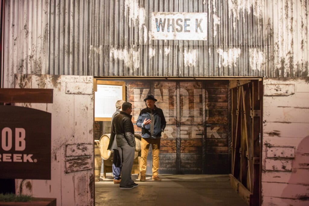 Guests entering a weathered boxcar set on the Beam Suntory Bourbon Legends Boxcar Tour