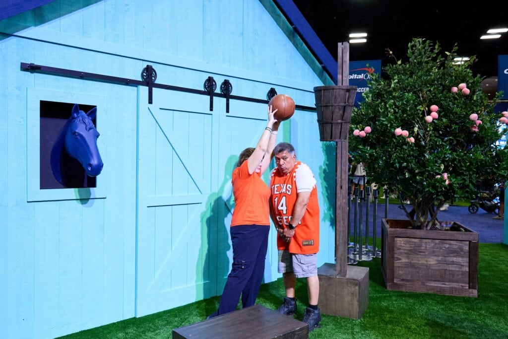 Fan shooting a basket at the Capital One farmhouse scenic
