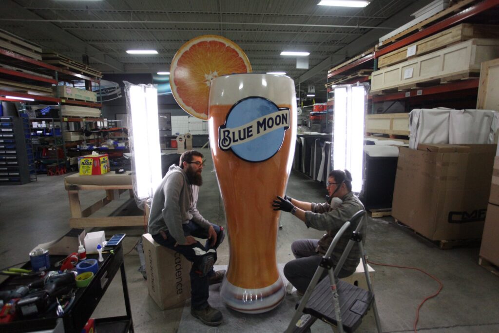 Fabricators finishing the oversized Blue Moon glass in the Cadence shop