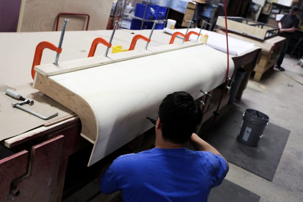 Fabricator shaping a curved panel in the Cadence shop