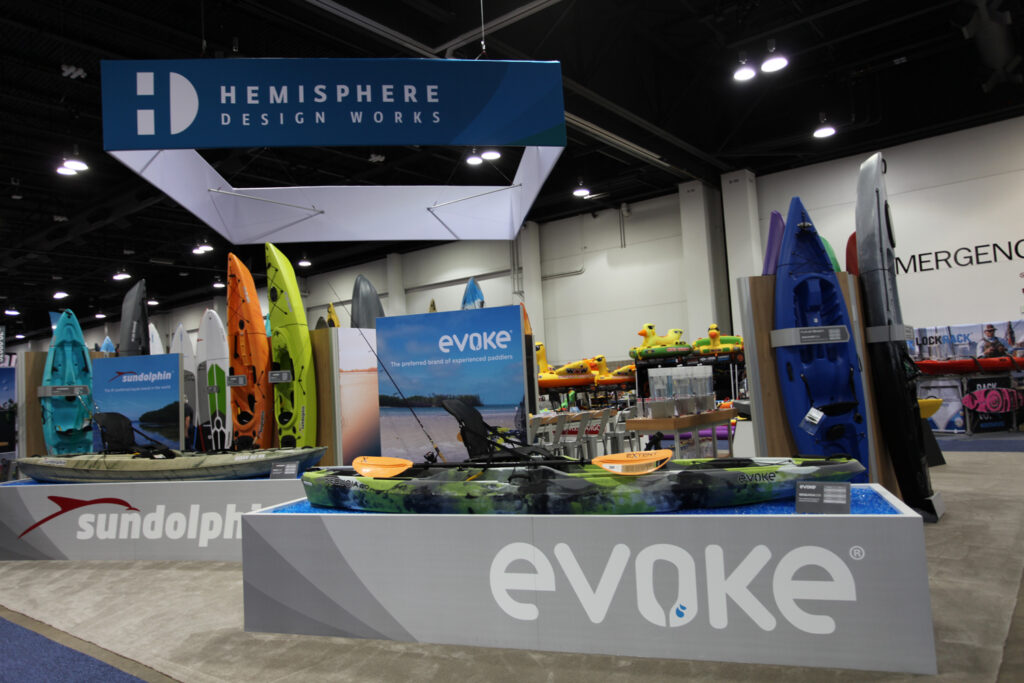 Hemisphere Design Works booth displaying Evoke, Sun Dolphin, and Future Beach kayaks