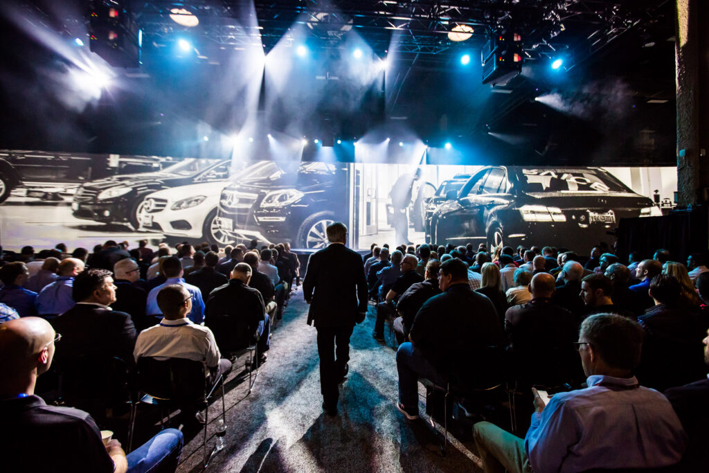 General session audience facing a large LED stage at the Mercedes-Benz National Parts and Service Managers Meeting