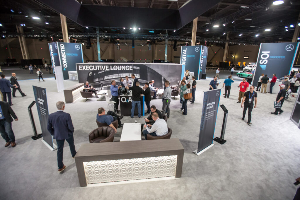 Custom expo floor with lounge seating and branded towers at a private dealer meeting